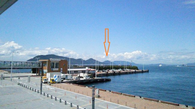 フェリー乗り場からの景色　矢印が男木島　左手の山並みが女木島　奥に見えるのは豊島